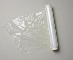 roll of transparent cling film for packaging ona gray background, top view photo