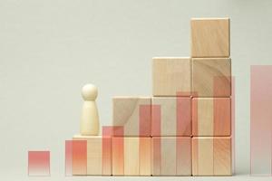 wooden figurine of a man stands on a staircase made of blocks on the first step. The concept of achieving the set goals in business, career growth photo