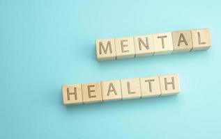 wooden cubes with the inscription mental health on a blue background photo