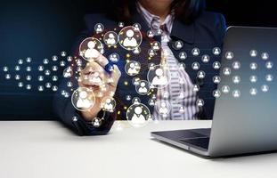 A woman in a suit sits at a table and works at a computer, the concept of finding a team for remote work. Recruitment photo