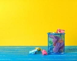 blue metal bucket filled with crumpled  paper photo