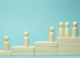 wooden figures of men on a ladder made of blocks. The concept of career advancement, starting at work, achieving goals photo