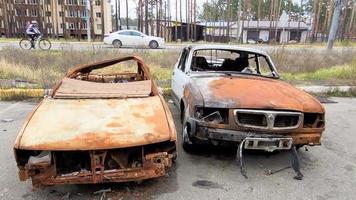 vue des voitures incendiées après les attaques à la roquette. guerre de la russie contre l'ukraine. véhicule civil après l'incendie. cimetière de voitures dans la ville d'irpin. tas de métal rouillé. pièces en fer d'une voiture brûlée video