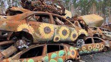 vista de autos quemados después de ataques con cohetes. guerra de rusia contra ucrania. vehículo civil después del incendio. cementerio de autos en la ciudad de irpin. montón de metal oxidado. piezas de hierro de un coche quemado video