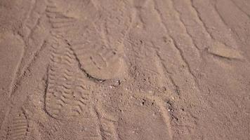 Fußabdrücke auf Sand, auf ein hell, sonnig Tag, im das großartig Sand Neigung oben Sicht. Video Bewegung 4k Aufnahmen mit Platz zum Text