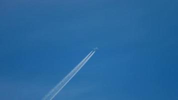 contrails in de blauwe lucht. vliegtuig dat hoog vliegt. video