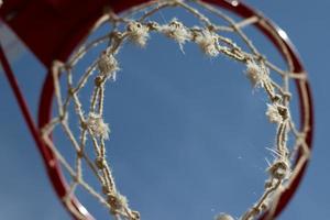 Basketball hoop ring close-up bottom view with sky background, copy space photo