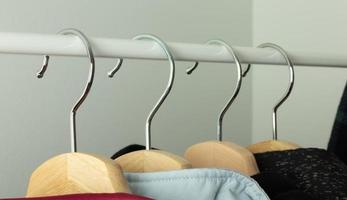 Clothes hangers on the bar in a clothing store. Retail store business illustration, hanger close-up photo