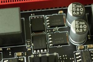 transistores, papas fritas y otro elementos en el tarjeta madre eléctrico circuito de cerca foto