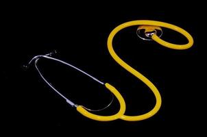 Yellow stethoscope on black background photo