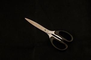 Scissors on black background photo