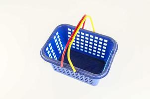 Plastic shopping basket on light background photo