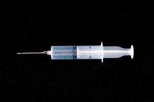 Syringe on black background photo