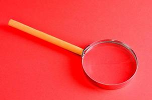 Magnifying glass on red background photo