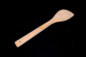 Wooden spoon on black background photo