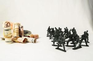 juguete soldados rodeando dinero foto