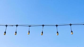 Round tube external lamp. Continue lined up on the rope. under the blue sky for background. photo