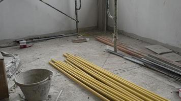 amarillo cloruro de polivinilo tubo apilado arriba en un construcción edificio. a lo largo con otro construcción equipo metido dentro el edificio. foto