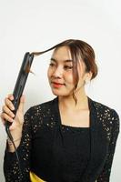 Asian woman styles her hair, photo