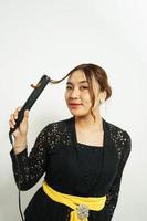 Asian woman styles her hair, photo