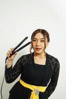 Asian woman styles her hair, photo