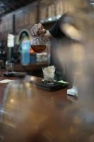 arábica café es siendo vertido dentro un vaso lleno con hielo. foto