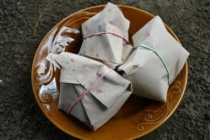 A rice wrap is positioned against a sea sand background. photo