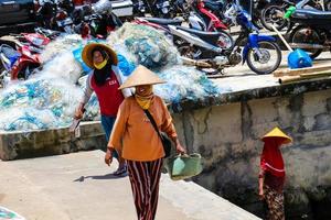 Yogyakarta, Indonesia in November 2022. Female fishermen who are also fish sellers at Baron Beach are washing their equipment photo