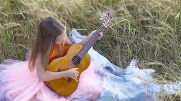 aanbiddelijk kleuter meisje in tarwe veld- Aan warm en zonnig zomer dag video