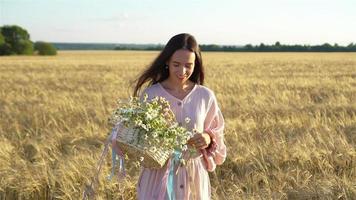 Beautiful girl in wheat field with ripe wheat in hands video