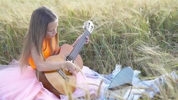 aanbiddelijk kleuter meisje in tarwe veld- Aan warm en zonnig zomer dag video