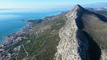 vista aérea de drones de la ciudad costera en croacia. montaña sobre la ciudad. zona del mar adriático y dalmacia. destino de viajes y vacaciones. video