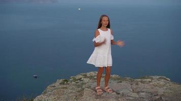 Little girl on top of a mountain enjoying valley view before sunset video