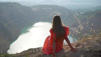 Little girl near the lake at the day time with amazing nature on background video