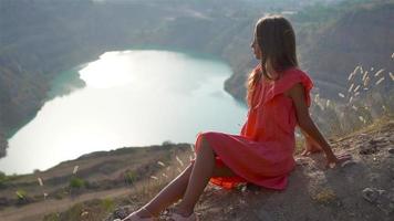 poco ragazza vicino il lago a il giorno tempo con sorprendente natura su sfondo video