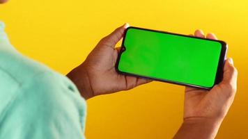 Topp view of mans hand using smart phone on yellow background video