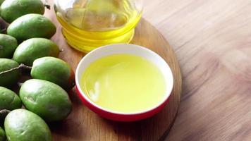 Bottle of olive oil and fresh olive in a container on chopping board video