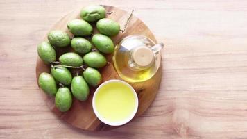 Bottle of olive oil and fresh olive in a container on table video