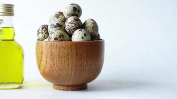 Top view of Quails eggs in a bowl with oil on white background video