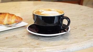 uma copo do atrasado café com flor forma Projeto em topo às cafeteria . video