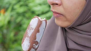 Slow motion of young woman eating chocolate ice cream video