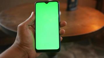 Man hand using smart phone with green screen on table video