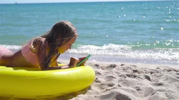 adorável menina em inflável ar colchão em a de praia video