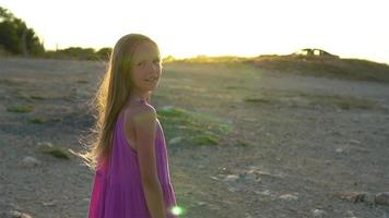kleines Mädchen auf einem Berg mit Blick auf das Tal vor Sonnenuntergang video