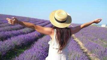 mujer en el campo de flores de lavanda al atardecer con vestido blanco y sombrero video