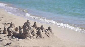 castelo de areia na praia tropical branca com brinquedos de plástico para crianças video
