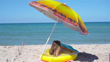 adorable niña en inflable aire colchón en el playa video