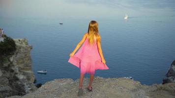 Little girl on top of a mountain enjoying valley view before sunset video