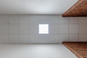 cassette stretched or suspended ceiling with square halogen spots lamps and drywall construction in empty room in house or office with column. Looking up view photo