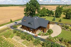 aerial panoramic view on wooden eco house or homestead in green village photo